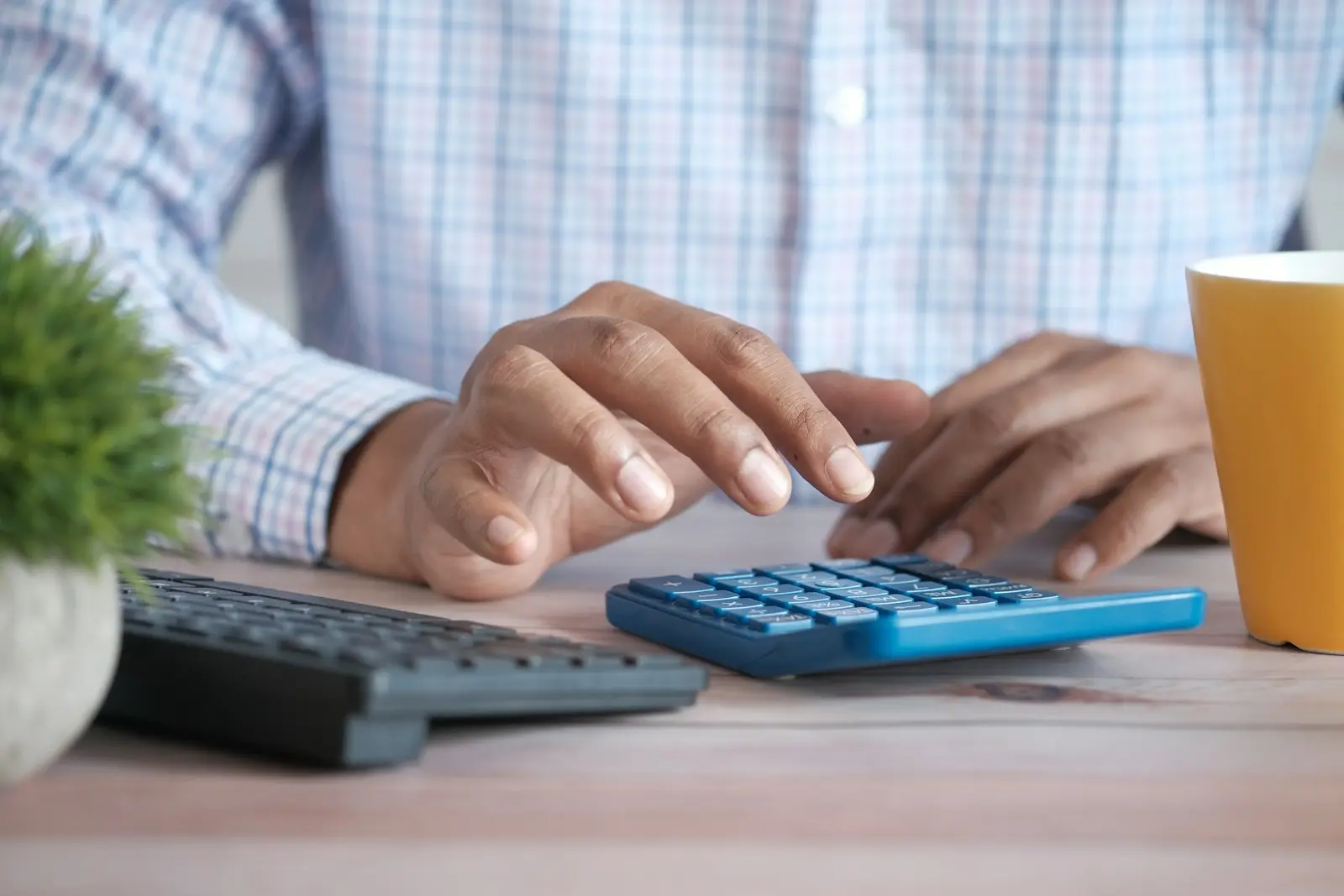 Hands using a calculator at a desk