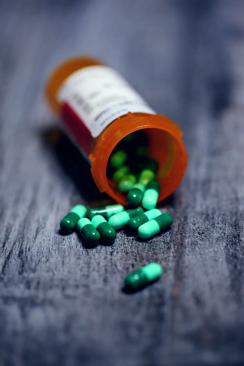 A prescription bottle with capsules spilling out