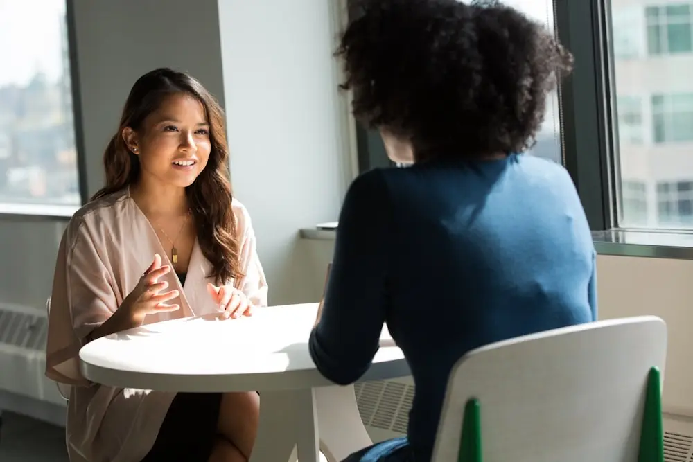 Two people in a bright room having a conversation
